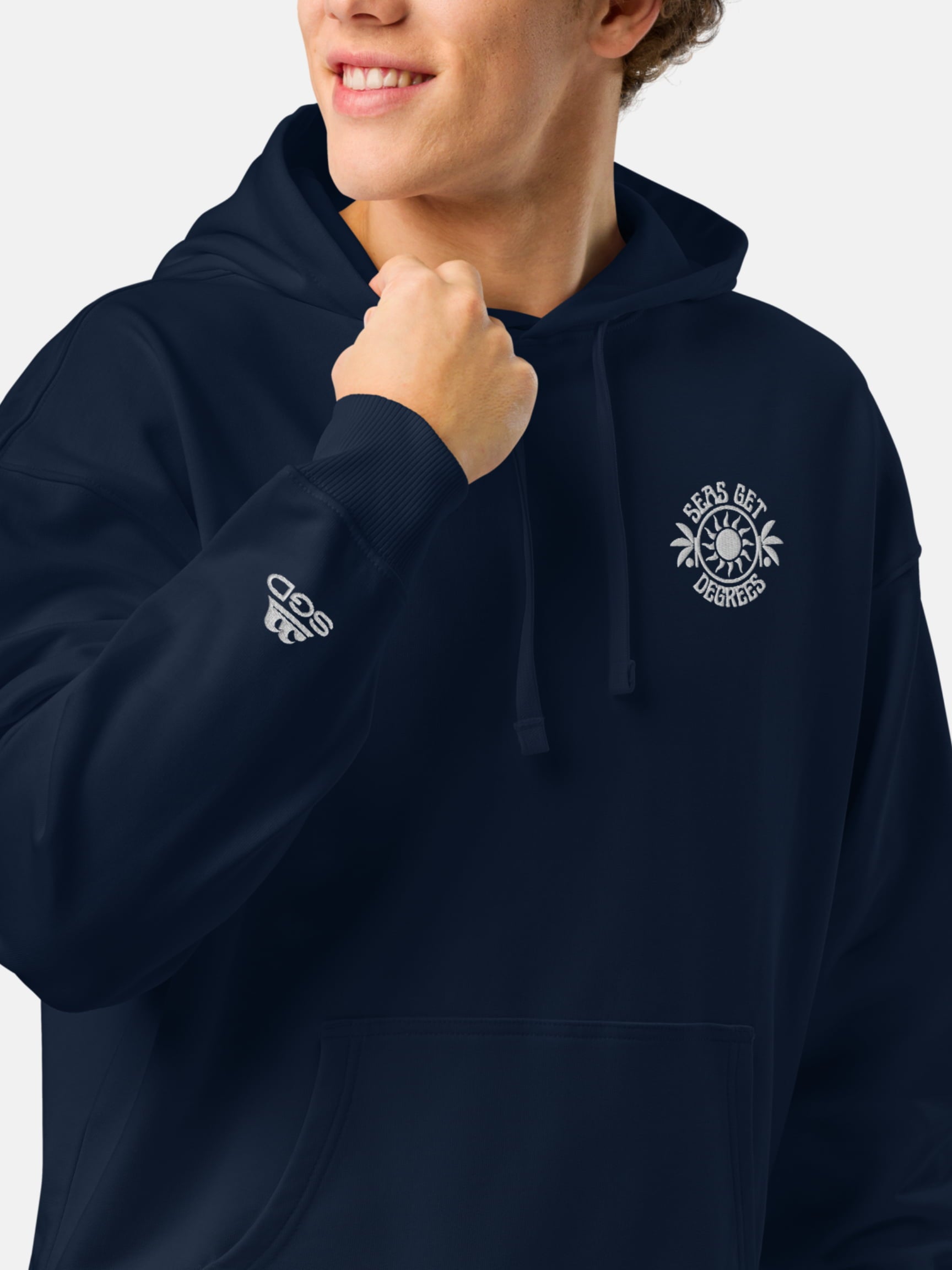 Model wearing Chase the Sun Oversized Embroidered Hoodie front left in navy — Seas Get Degrees men's coastal hoodie