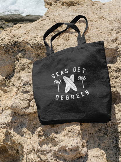 Keepn' Coastal Tote Bag lifestyle shot at the beach in black — Seas Get Degrees