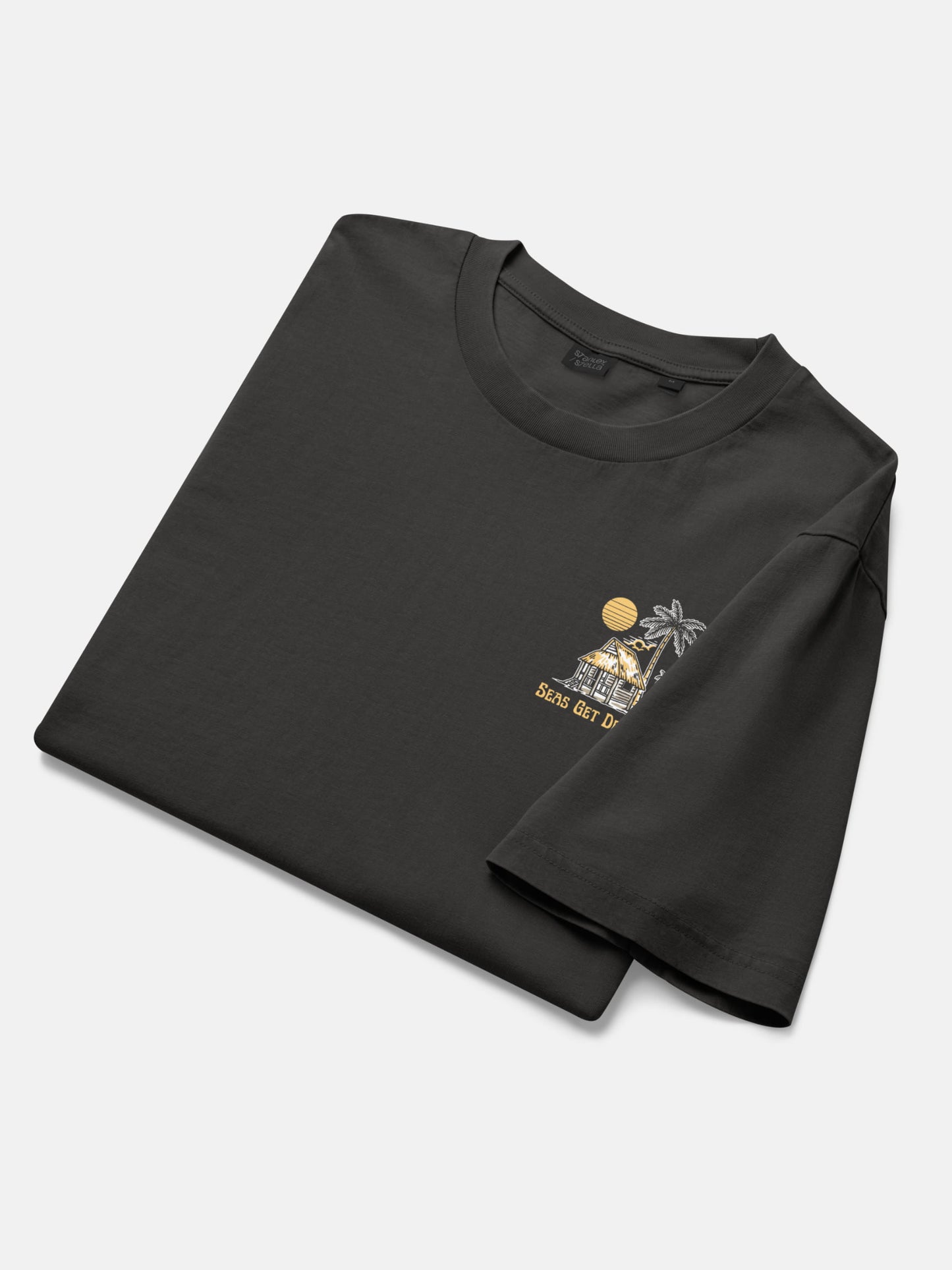 Lost and Found Tee folded flat lay in black rock — Seas Get Degrees